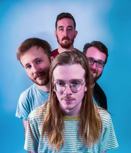 Four men in t-shirts face the camera.