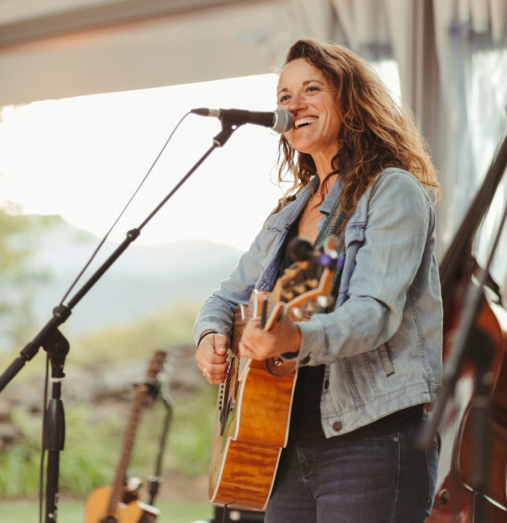 Jess Clemons playing guitar and singing.