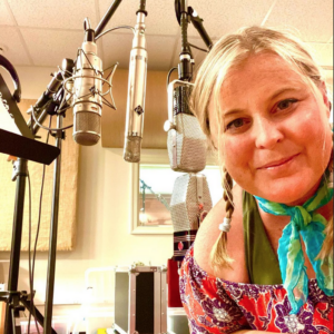 Corrie Lynn Green poses next to three vocal microphones.