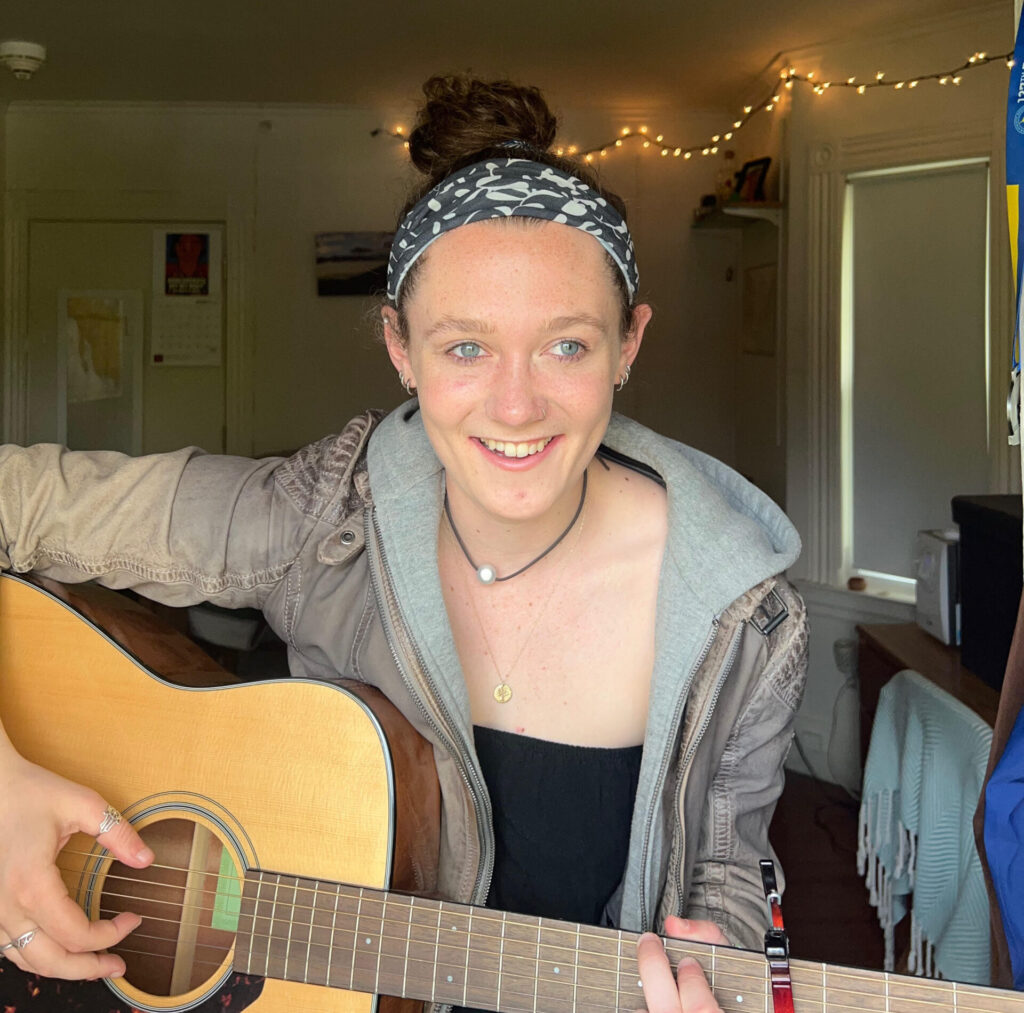 Maggie Monaghan holding a guitar.