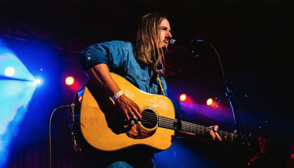 Reece Sullivan playing guitar onstage.